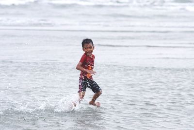 Cheerful boy running at sea