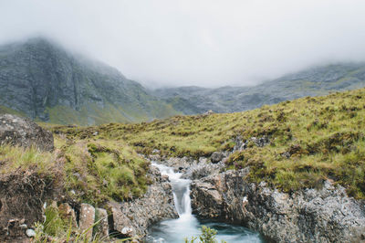 Scenic view of waterfall against sky