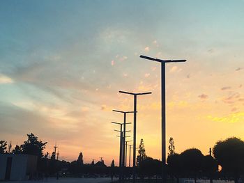 Silhouette street against sky during sunset