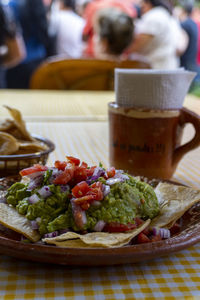 Fresh homemade guacamole piled on a seasoned tortilla chip close up and ready to eat guacamole