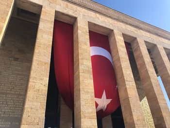 Low angle view of flag on building against sky