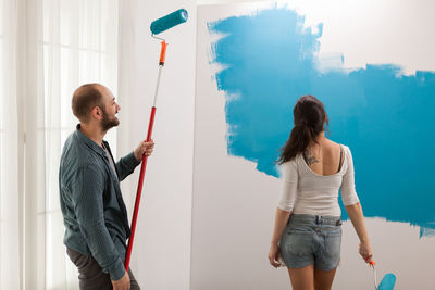 Young couple standing against wall