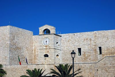 Low angle view of bell tower against blue sky