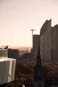 Buildings in city against clear sky