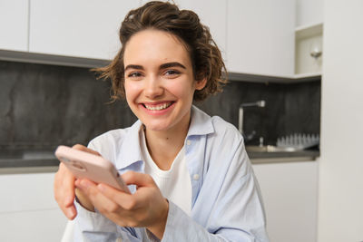 Portrait of young woman using mobile phone