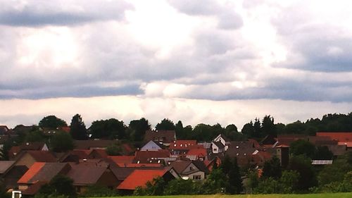 Houses against cloudy sky