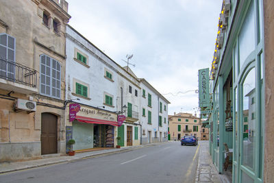 Road amidst buildings in city against sky