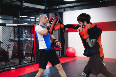 Men practicing in boxing ring