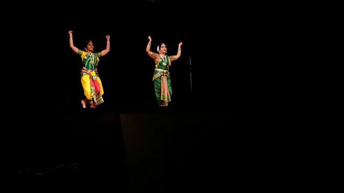 Woman standing against black background