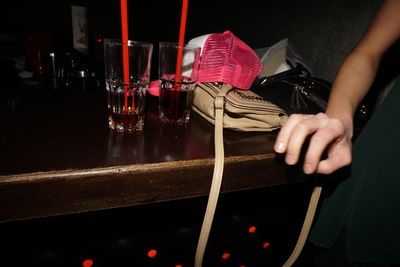 Midsection of man drinking glass on table