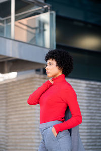 A young african-american businesswoman wearing a red turtleneck and a suit in a business building