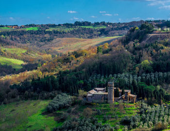Scenic view of trees and houses on field against sky