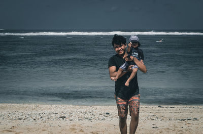 Father and son play on the beach