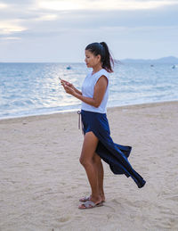 Side view of woman standing at beach