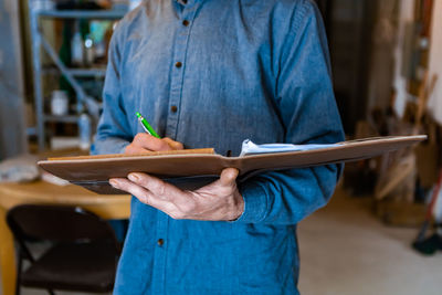 Midsection of man working on wood