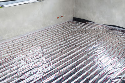 White pipes of underfloor heating systems, distributed in an individual family house on foil.