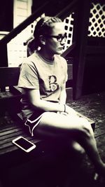 Portrait of young woman sitting on wall