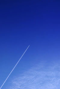 Low angle view of vapor trail in blue sky