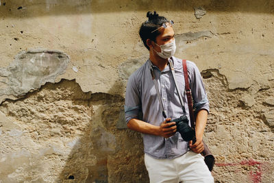 Full length of man standing against wall