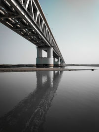 Low angle view of bridge over river against clear sky