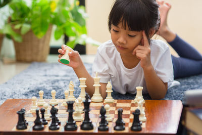 Full length of boy playing on chess board