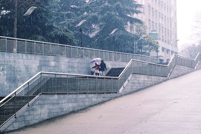 Man and woman walking on staircase in rainy season