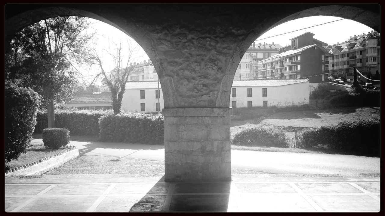 architecture, built structure, transfer print, arch, building exterior, auto post production filter, tree, bridge - man made structure, sunlight, connection, shadow, day, clear sky, architectural column, no people, outdoors, archway, city, arch bridge, house