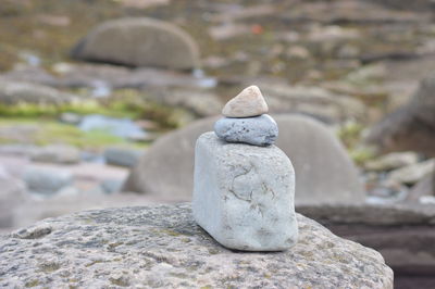 Close-up of stone stack on rock at beach