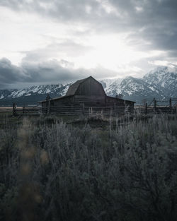 Built structure on land by mountain against sky