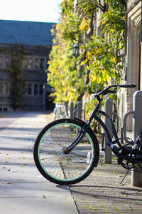 Bicycle on street against building in city