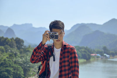 Man standing against mountain range against sky