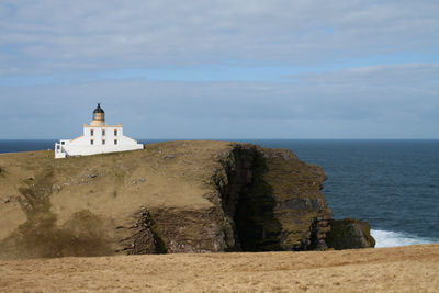 Scenic view of sea by building against sky