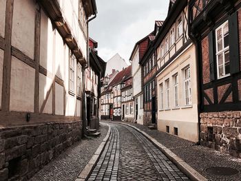 Road amidst buildings against sky