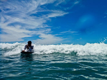 Man surfing in sea against sky