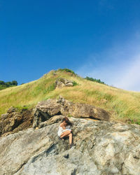 Man on rock against sky