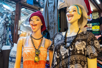 Portrait of smiling young woman standing against store