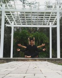 Portrait of young woman with arms outstretched