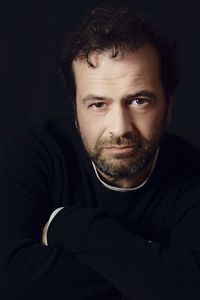 Portrait of young man against black background