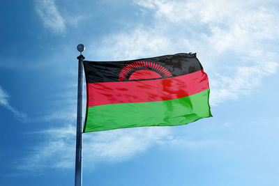 Low angle view of flag against blue sky