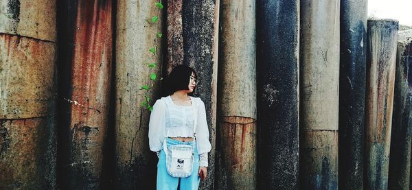 Rear view of woman standing against wall