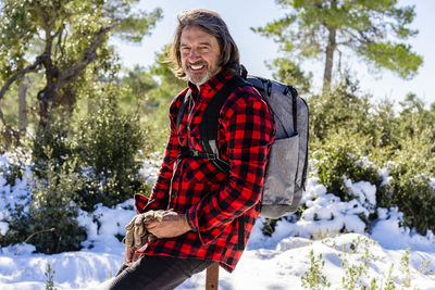 Rear view of man standing on snow covered trees