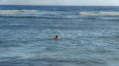 Woman surfboarding at sea