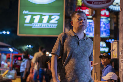 Full length of man standing in illuminated city