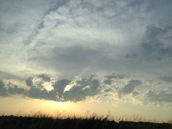 Silhouette of landscape against cloudy sky