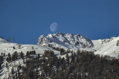 Scenic view of snowcapped mountains against clear blue sky