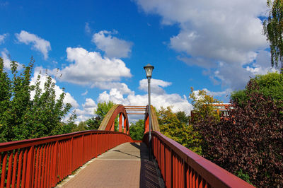 Footbridge over trees against sky