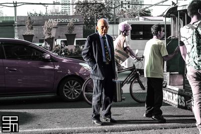 Friends standing by car in city