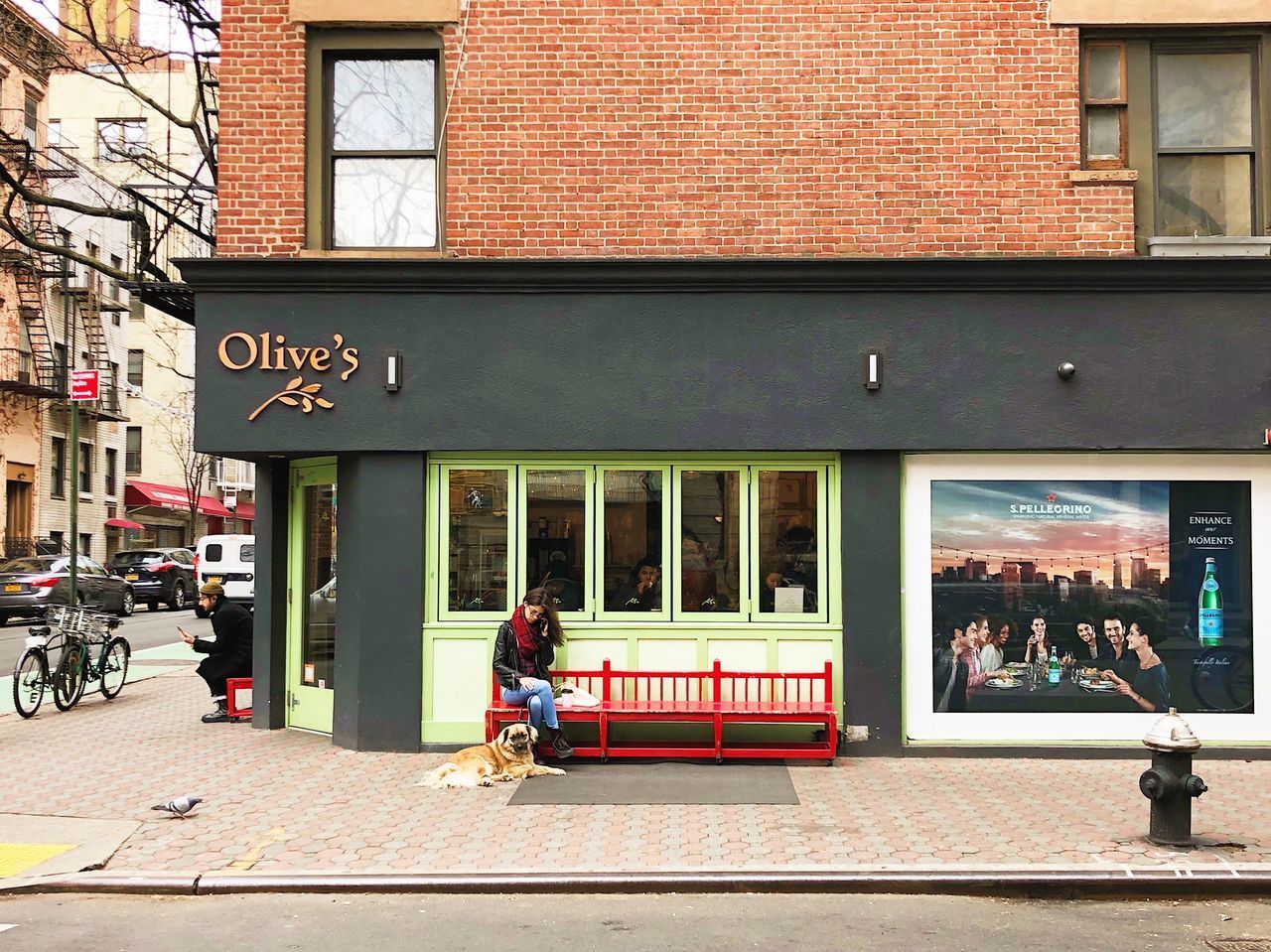 PEOPLE SITTING ON STREET BY BUILDING