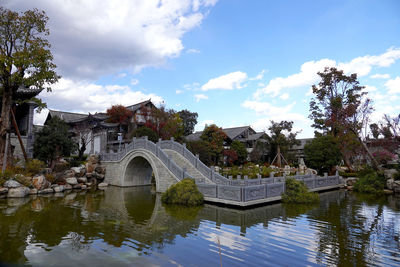 Arch bridge over river against sky