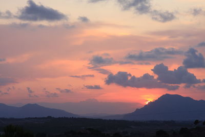 Scenic view of silhouette mountains against sky at sunset